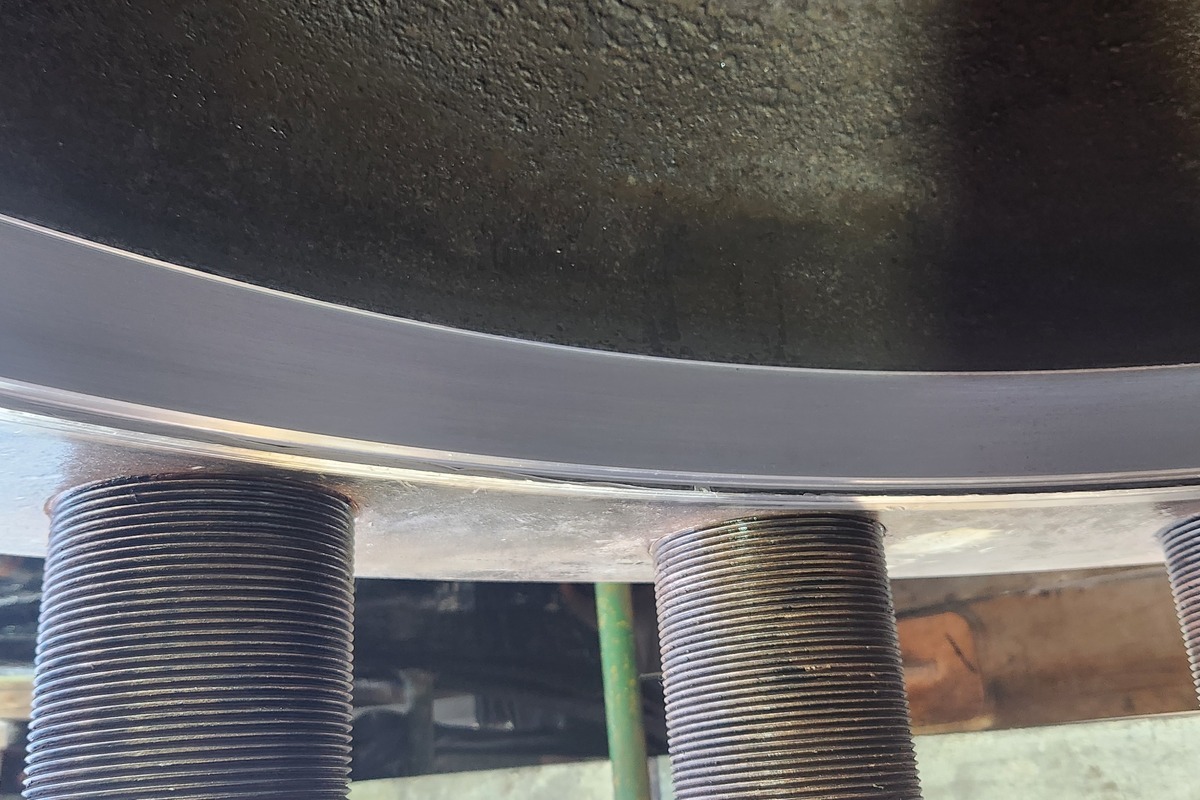 Finished taper machined onto the heat-exchanger cover sealing face — continuous, uniform surface around the bolt circle